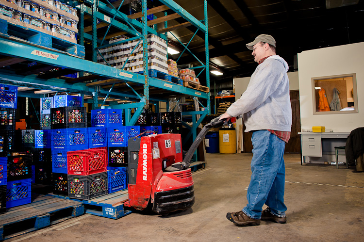 The FOOD Pantry warehouse, warehouse manager moving pallets into storage.